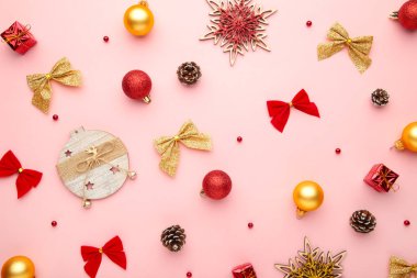 Pembe arka planda altın ve kırmızı süslemeli Noel kompozisyonu