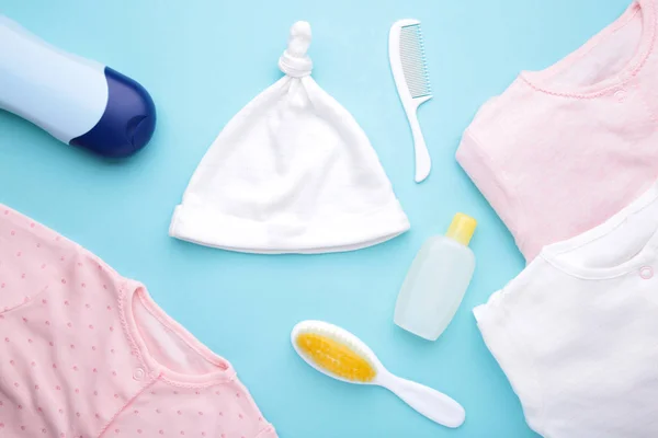Mavi arka planda duş aksesuarları olan bebek kıyafetleri. — Stok fotoğraf