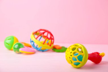 Pembe arka planda renkli çocuk çıngırakları. Bebek konsepti
