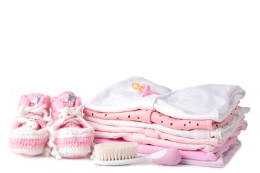 Beyaz arka planda izole edilmiş bebek kıyafetleri ve tarak.