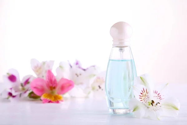 Flacon de parfum avec fleurs sur fond blanc, vue de dessus — Photo