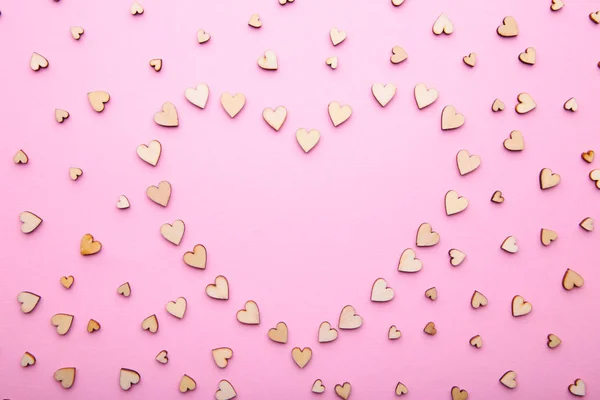 Heart from little wooden hearts on pink background Stock Picture