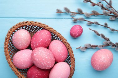 Sepette pembe paskalya yumurtaları ve mavi arka planda söğüt dalları