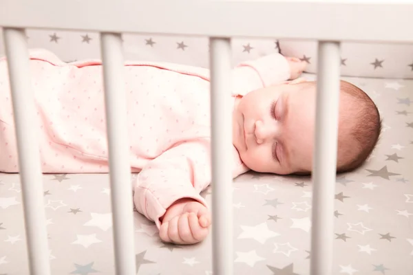 Söt baby sover i en vit spjälsäng — Stockfoto