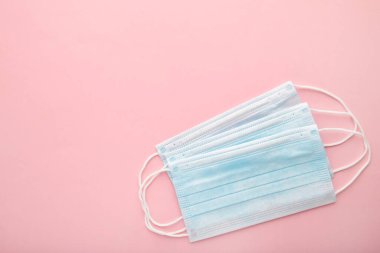Pembe arka planda tıbbi maskeler. Coronavirus, üst görünüm