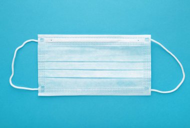 Mavi arka planda tıbbi maske. Coronavirus, üst görünüm