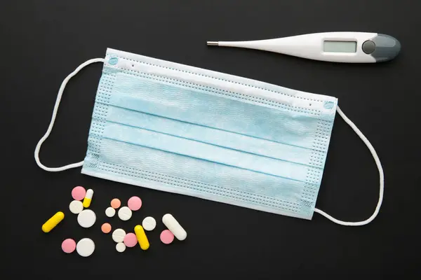 医用温度計と黒の錠剤とマスク コロナウイルス — ストック写真