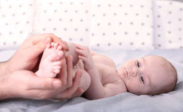 Hände Des Vaters Halten Kleine Babyfüße Auf Weißem Bett Ansicht — Stockfoto