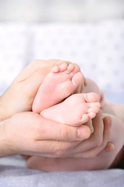 Hände Des Vaters Halten Kleine Babyfüße Auf Weißem Bett Ansicht — Stockfoto