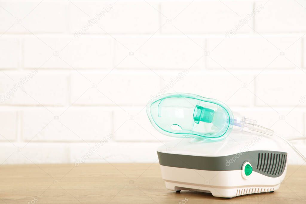 Compressor nebulizer with mask on table with copy space.