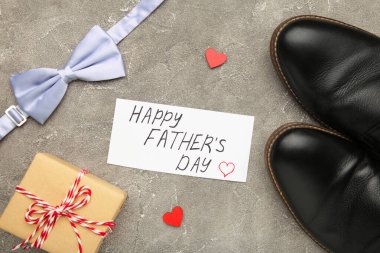 Mutlu Babalar Günü mesajları ve gri beton arka planda siyah ayakkabılar. Üst görünüm