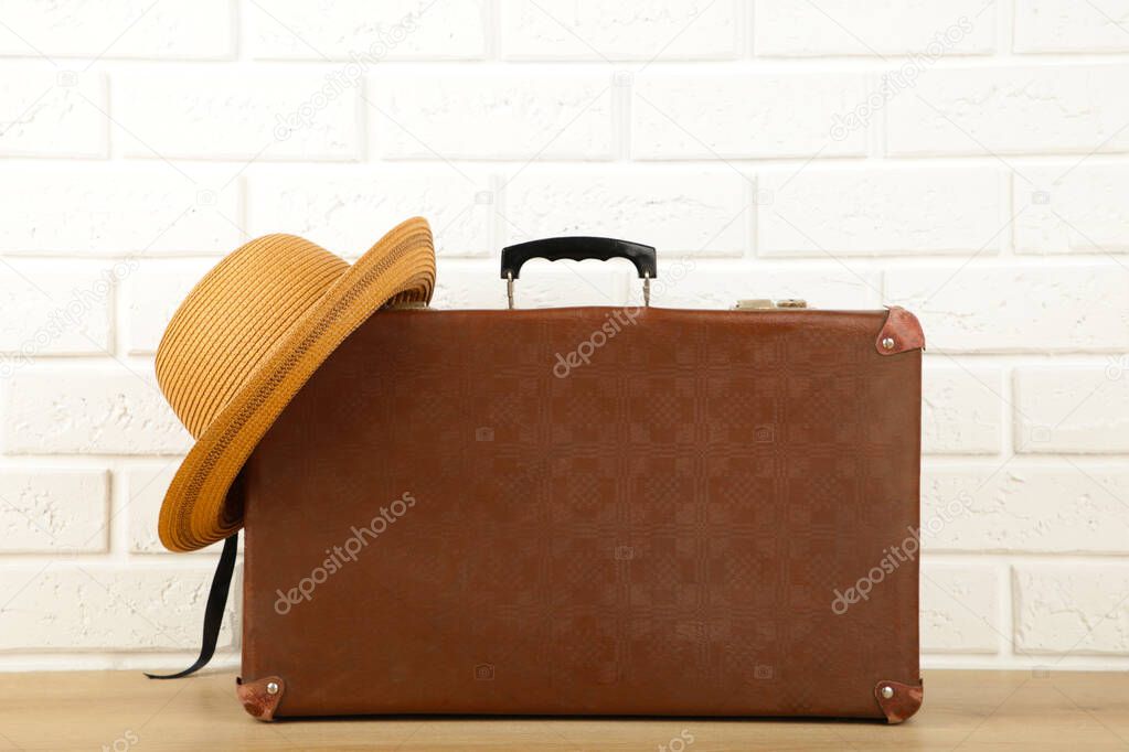 Leather old suitcase with hat on white background. Top view