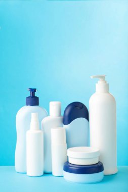 Mavi arka planda farklı kozmetik şişeler. Şişeler.