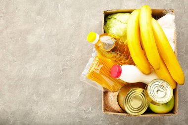 Gri beton arka planda gıda bağışları. Boşluğu kopyala