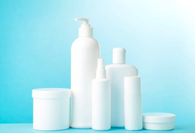 Mavi arka planda beyaz kozmetik şişeler. Şişeler.