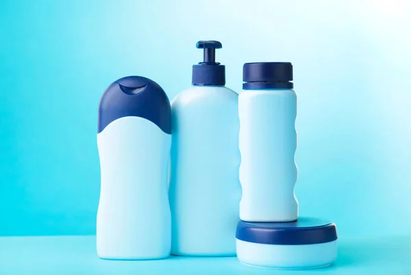 Blue cosmetic bottles on blue background. Set of bottles