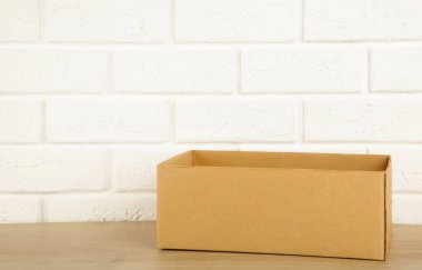 Beyaz tuğla duvar zemininde karton kutu.