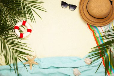 Açık arkaplanda palmiye yaprakları olan plaj aksesuarları