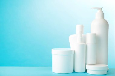 Mavi arka planda beyaz kozmetik şişeler. Şişeler.