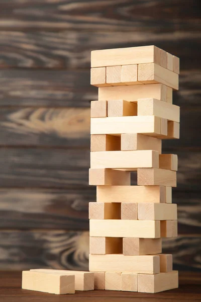 木製のJengaゲームとビジネスリスクの概念 茶色の背景に木製のブロック — ストック写真