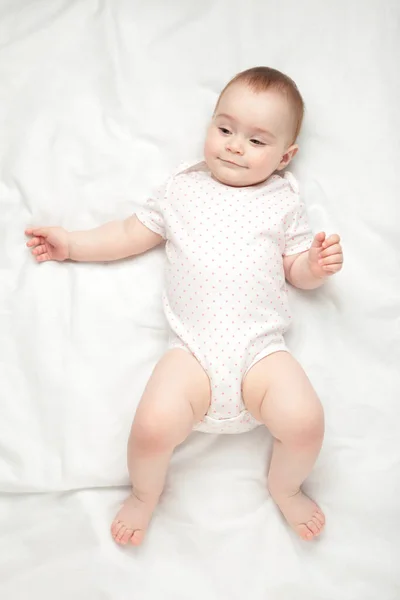 可愛い赤ちゃんが横になり 白いベッドで笑顔 トップ表示 — ストック写真
