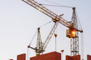 İki vinç ve bina faaliyeti. İnşaat alanı arka planı.