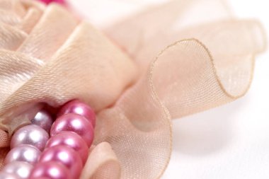 Kumaş kurdele ve inci gibi incilerden yapılmış çiçek broşu.