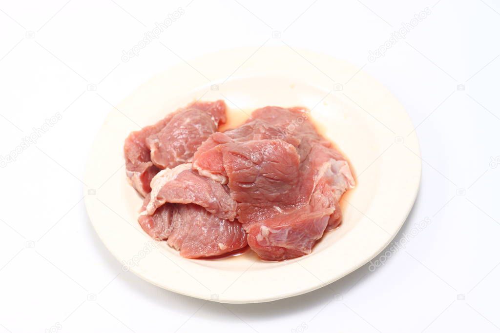 A plate of fresh raw meat on a white isolated background 