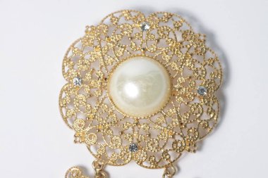 İnci ve elmaslı altın broş beyaz izole bir zemin üzerinde
