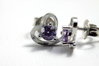 Mor kristal taşlı beyaz altın kalp şeklindeki kulak şeklindeki yakın plan çekimleri.