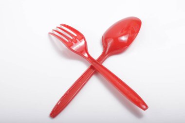 İzole edilmiş beyaz arka planda kırmızı plastik çatal bıçak.