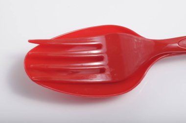 İzole edilmiş beyaz arka planda kırmızı plastik çatal bıçak.
