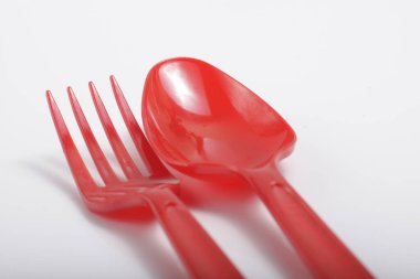 İzole edilmiş beyaz arka planda kırmızı plastik çatal bıçak.