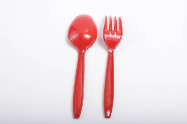 İzole edilmiş beyaz arka planda kırmızı plastik çatal bıçak.