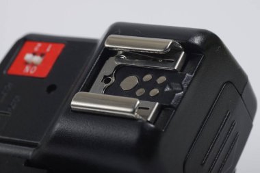 Beyaz arkaplanda izole edilmiş siyah kamera flaş tetikleyicisinin yakın çekim görüntüsü