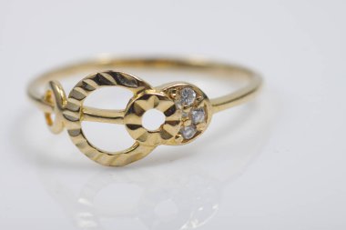 İzole edilmiş bir arka planda altın yüzüklü mücevher fotoğrafı.