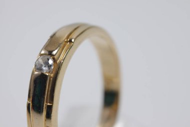 İzole edilmiş bir arka planda altın yüzüklü mücevher fotoğrafı.