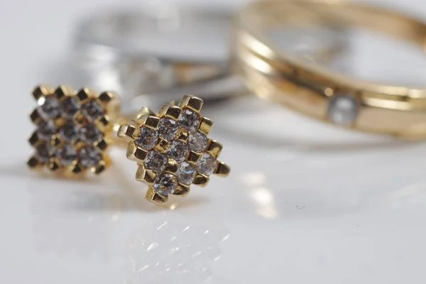 由耳环 婚戒和结婚戒指组成的精美金饰品的特写 — 图库照片