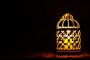 Kırsal bir ahşap masanın üzerindeki mum fenerini yakın plan çek.