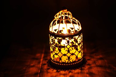 Kırsal bir ahşap masanın üzerindeki mum fenerini yakın plan çek.