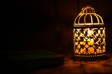 Kırsal bir ahşap masanın üzerindeki mum fenerini yakın plan çek.