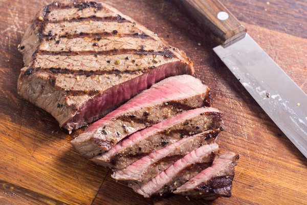 Grilled beef steak on cutting board . Food background