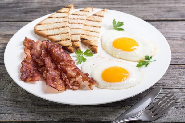 Morgenmad med æg bacon og toasts - Stock-foto