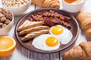 Yumurta, domuz pastırması ve kruvasan kahvaltı 