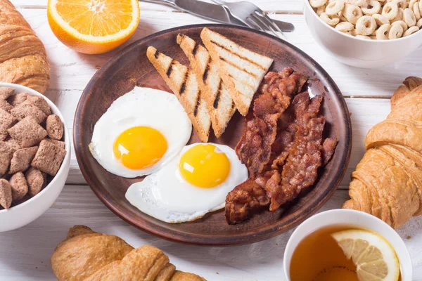 Frukost med ägg, bacon och croissanter — Stockfoto