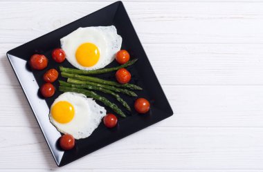 Yumurta, kuşkonmaz ve domatesli sağlıklı bir kahvaltı. Sebze arka planı