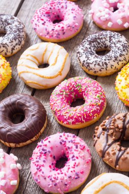 Çikolata kaplı, pembe jöleli ve serpiştirilmiş çeşitli çörekler. Üst görünüm