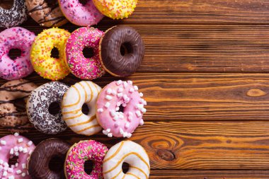 Çikolata kaplı, pembe jöleli ve serpiştirilmiş çeşitli çörekler. Üst görünüm