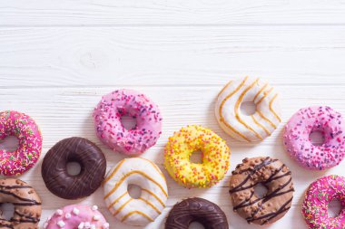 Çikolata kaplı, pembe jöleli ve serpiştirilmiş çeşitli çörekler. Üst görünüm