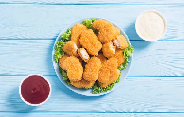 Chicken golden nuggets in plate on rustic background . Unhealthy fast food